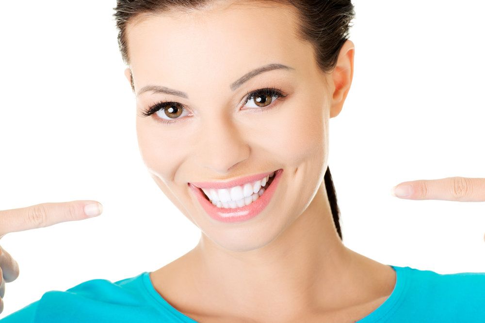 Young woman with white teeth on white background.