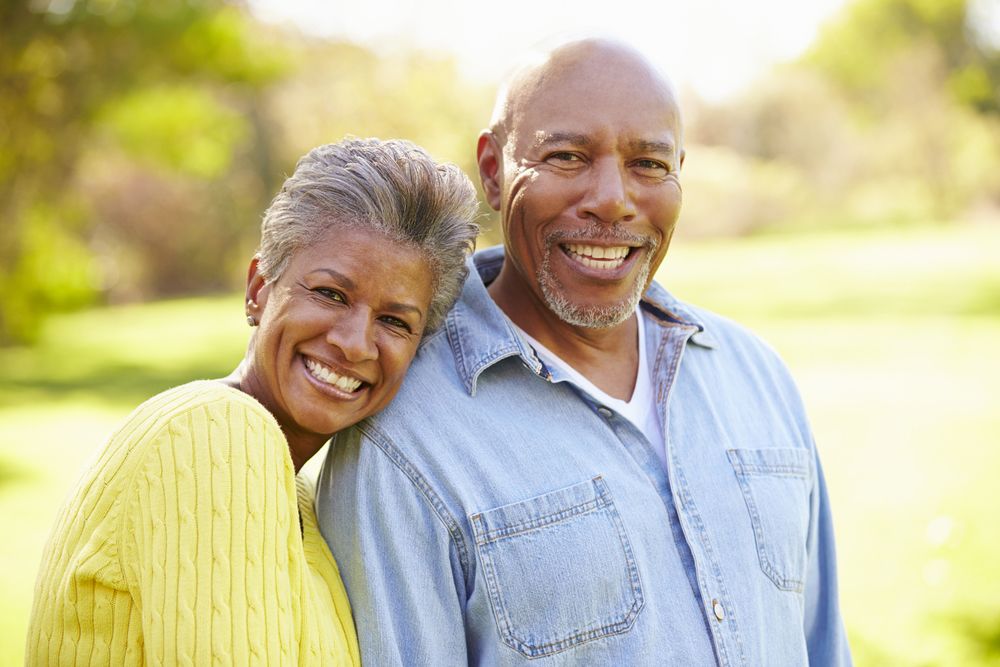 Smiling couple with woman resting head on man's shoulder