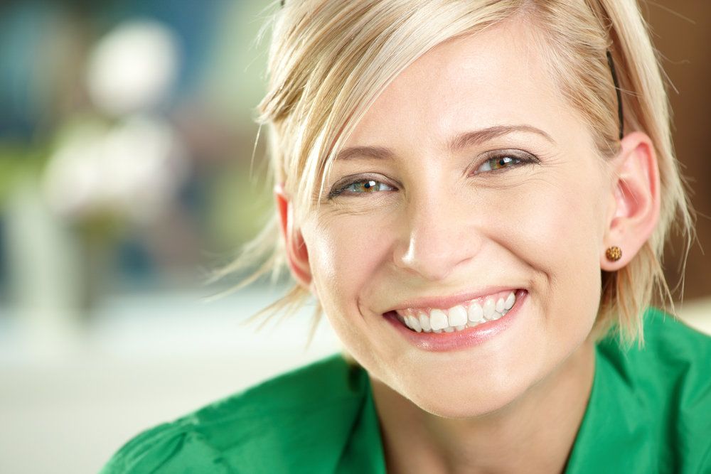 Smiling blond woman in green shirt